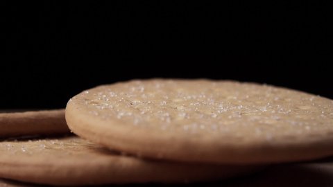 Sugar crystals are falling on cookies closeup in slow motion. Macro