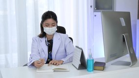 Young female doctor wearing face mask in white medical uniform and stethoscope  with laptop sit at modern workplace in hospital.