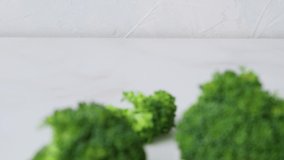 Slowly shifting focus from focus to defocus of fresh green broccoli on white background