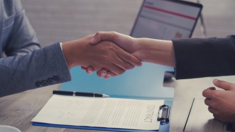 Close up of Asian businessman shaking hands partnership deal business in the office.