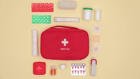 Packing of first aid kit on color background, video with stop motion effect