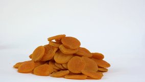 Sun-dried fruits isolated on white. Dry apricot on white background. Naturally dried apricot.  Product for sale. Footage for advertising and marketing. Dolly shot. Slider shot. High 4k video.