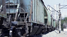 Close up of freight train passing by. Clip. Reliability of freight and logistics, concept of delivery and transportation, moving cargo train wagons.