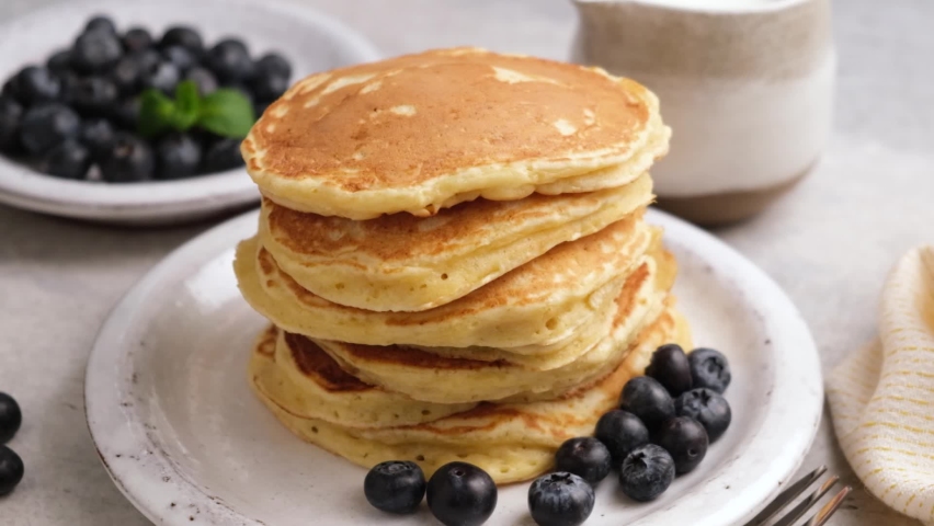 Maple syrup pouring over stack of pancakes in slow motion. Sweet breakfast food, pancakes with syrup and blueberries Royalty-Free Stock Footage #1065339817