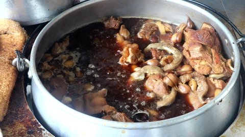 Pot full of steaming hot and aromatic bak kut teh with herbs, pork, intestines. Delicacies in Malaysia.