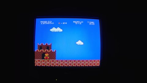 Ukraine, Dnipro 20 Feb 2022: Gameplay of the popular video game Super Mario Bros. Retro video game for Nintendo 80s on the screen of an old TV in a dark room. Noisy pixelated background in retro TV