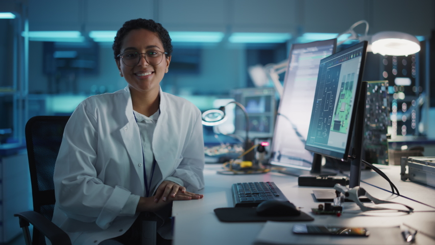 Beautiful Black Latin Woman Wearing Glasses Smiling Charmingly Looking at Camera. Young Intelligent Female Scientist Working in Laboratory. Technological Laboratory in Bokeh Blue as Background | Shutterstock HD Video #1065341845