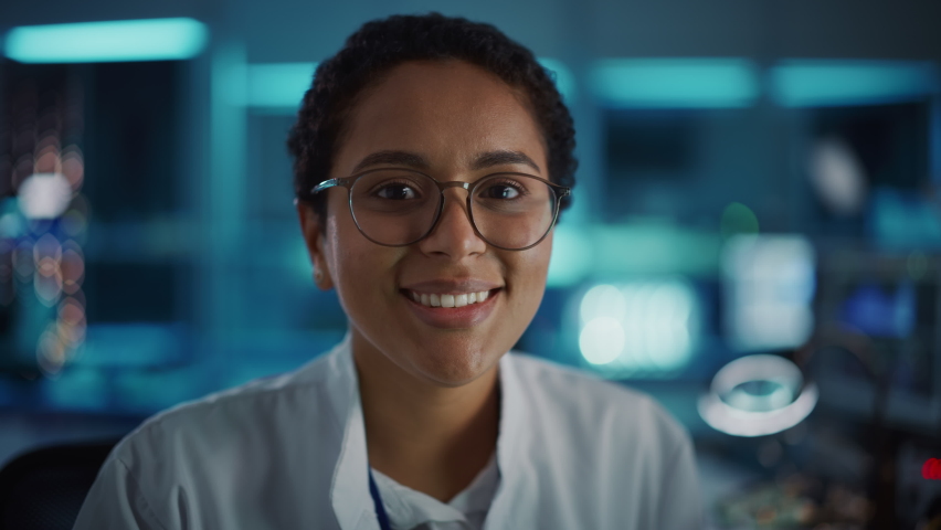 Beautiful Black Latin Woman Wearing Glasses Smiling Charmingly Looking at Camera. Young Intelligent Female Scientist Working in Laboratory. Technological Bokeh Blue Background. Close-up Shot | Shutterstock HD Video #1065341854