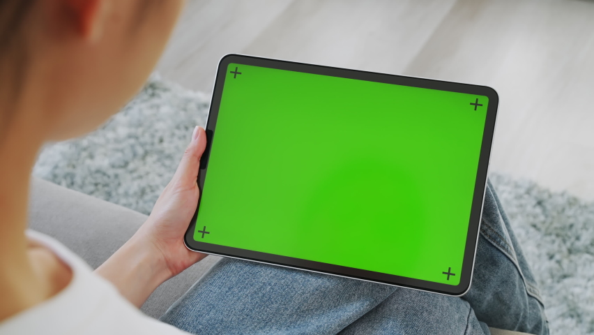 Close up of woman holding in hands a digital tablet with green screen for internet online, chromakey screen for advertising. Royalty-Free Stock Footage #1065346099