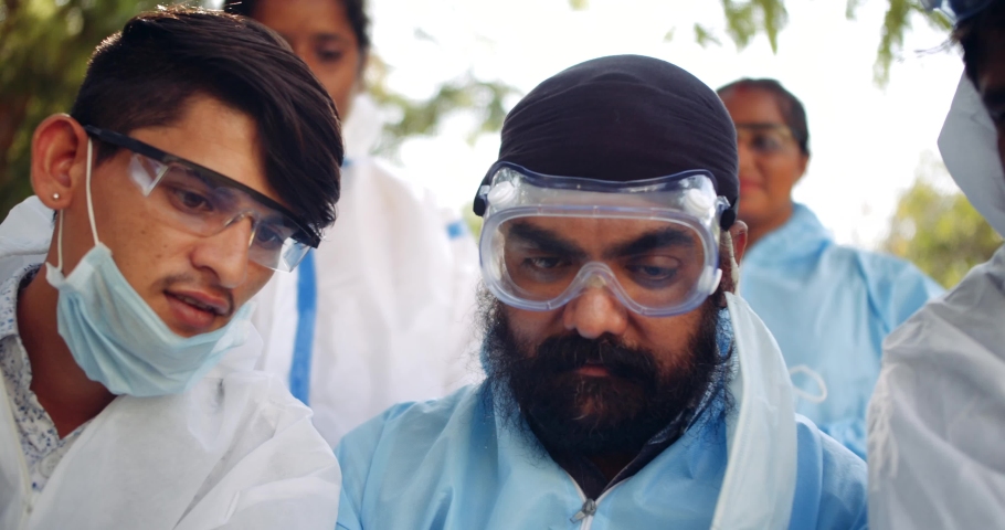 Slow-motion of Indian doctors and nurses, women and men, using smart phone mobile handy technology digital device for news information knowledge educate learn awareness share bond outdoors