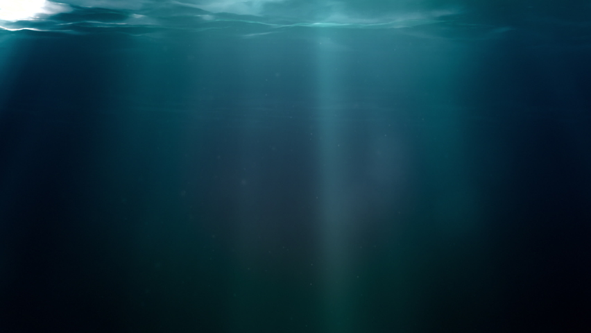 Sun light beams shining from above through deep clear blue water surface creating zen-like rays and reflections on the underwater dust and bubbles. Looped clear concept template shot with copy space. Royalty-Free Stock Footage #1065353248