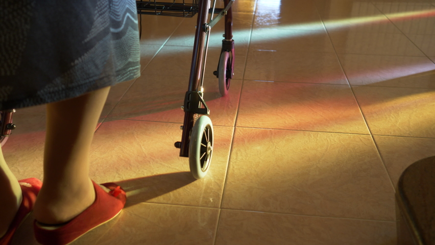 Elderly woman walks indoors with the walker. Detail of the legs and slow motion scene. Royalty-Free Stock Footage #1065356968