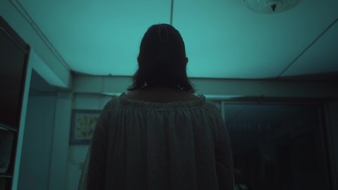 Asian female in white dress levitating forward in haunted house concept for halloween, horror scene, nightmare, unusual human behavior - 4k footage
