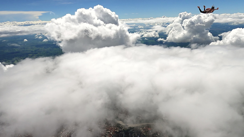 Image of a woman parachutist in casual clothes doing a dive among the clouds, in slow motion with 4K resolution. | Shutterstock HD Video #1065364444