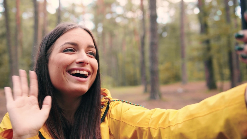 Happy hiker girl sitting in woods at day time and talking to friends over video call using smartphone. Royalty-Free Stock Footage #1065371668