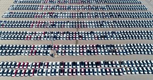 Parking lot from above in daytime. There is a lot of cars parked in the parking lot - aerial view with a drone - slow video 4K