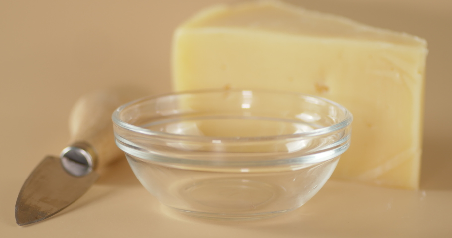 The creamy sauce flows into the glass bowl. On a gray background. | Shutterstock HD Video #1065384808