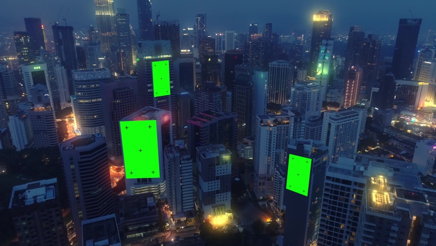 AERIAL. Top view of skyscrapers and green screen build board with tracking point. Bird view of modern city at night streets. Royalty-Free Stock Footage #1065386230