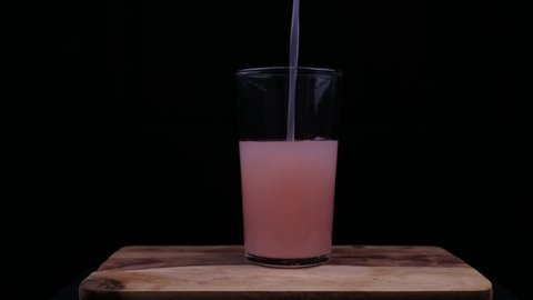 Closeup shot of hand poring fresh guava juice in glass