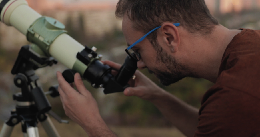 Amateur astronomer looking at the sky with a telescope.	
