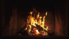 A Looping Clip of a Fireplace with Medium Size Flames Burning Fire Slow Motion. Warm Cozy Fireplace with Real Wood Burning in it Winter and Christmas Holidays Concept