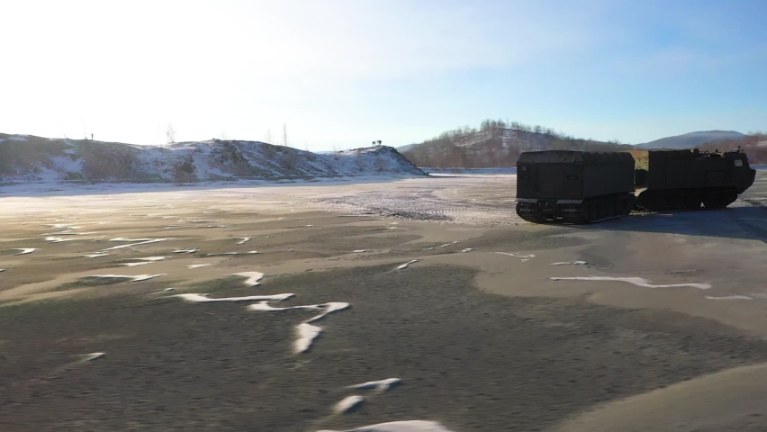 Military tracked all-terrain vehicle in motion at the quarry, general plan aerial photography