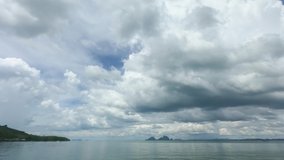 dramatic rain stormy clouds over southern Thailand sea. seascape cloudscape nature b-roll footage. sun rays shine through huge fluffy clouds in rainy day. dark clouds spinning horizontal toward island