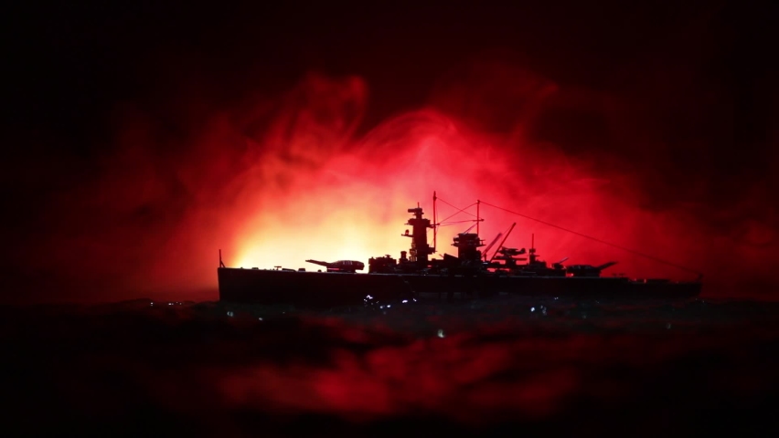 War concept. Night battle scene at sea. Dramatic toned clouds effect. Silhouette of the battle ship in night. Miniature creative table decoration. Selective focus