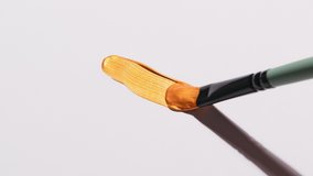 Close-up of hand artist holding  paint brush and drawing painting line gold paint. Smear paint on white background. - Powered by Shutterstock - Get 15% off with code: PIKWIZARD15