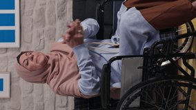 Sad disabled old woman with turban in a wheelchair alone in the living room at home.Video for the vertical story.
