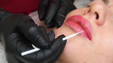 Moisturizing lips after procedures Close-up of permanent lip makeup. lip tattoo. Beautiful lips.