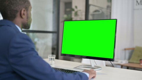 African Businessman Using Desktop with Green Chroma Key Screen 