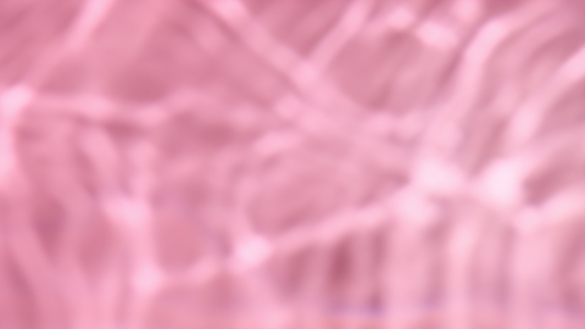 Pink water with light reflections and shadows surface texture. Blurred desaturated transparent clear water wave transparent background. Royalty-Free Stock Footage #1065457012