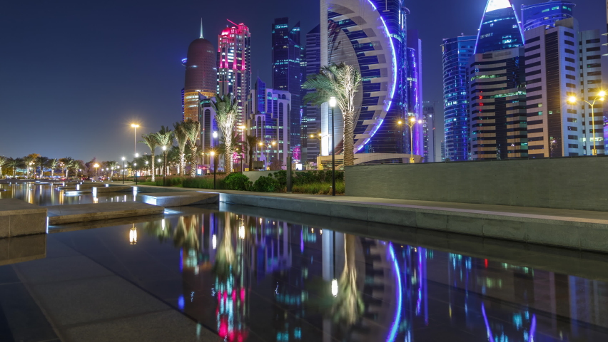 The skyline of Doha by night with starry sky seen from Park timelapse, Qatar. Illuminated skyscrapers and towers reflected in water of fountain | Shutterstock HD Video #1065464071