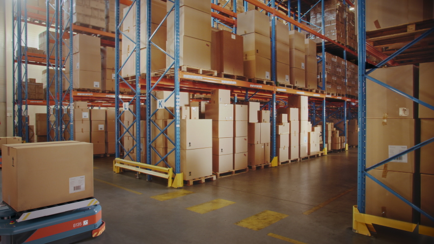 Future Technology: Automated Modern Retail Warehouse Delivery AGV Robots Transporting Cardboard Boxes in Distribution Logistics Center. Automated Guided Vehicles Delivering Goods, Products, Packages | Shutterstock HD Video #1065464995