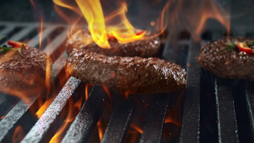 Barbecued Beef Burger Patty Falling onto Smoking and Flaming Grill Grate in 1000fps (Phantom Flex) Royalty-Free Stock Footage #1065468892