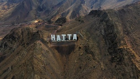 Hatta city welcoming sign written with large letters placed in Hajar mountains in Hatta enclave of Dubai in the United Arab Emirates aerial view