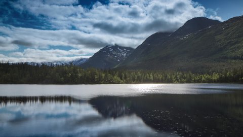 Time lapse forwards and backwards footage of clouds reflected over a clear fjord in norway