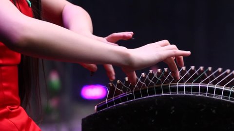 Close –up.Beautiful moving of female hands playing a traditional chinese instrument guzheng .