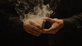 Close-up of a Magician's Hands Performing Card Trick . Throwing and Catching Cards in the Air on black Background with smoke . Card Mechanic .  Shot on ARRI Alexa cinema camera in Slow Motion 
