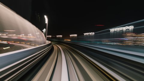 Point of view hyperlapse time-lapse of fast train travel forward on Yurikamome train line at night in Odaiba Tokyo, Japan. Railway transportation system, Asia tourism, transport technology concept