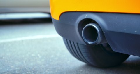 Close-up of the exhaust pipe of a working white car. Air Pollution Smoke From Car. Yellow car. Exhaust Pipe Muffler Shot on Cinema camera with 1.33x Anamorphic lens