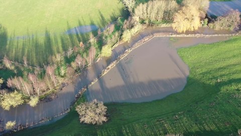 Aerial footage of the British country side fields in the winter time showing a river that has burst it's bank to overspill water on the fields, taken in the town of Wetherby in Yorkshire in the UK