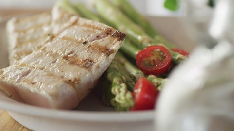 Fresh fish with asparagus and tomatoes, gourmet meal.