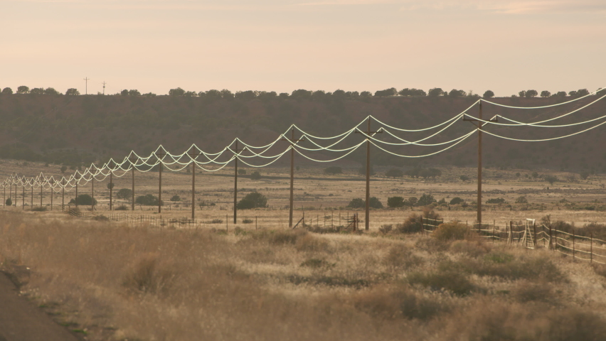 Utah circa-2020. Stabilized driving shot of road and power lines at sunset. Shot with Cineflex gimbal and RED 8K camera.
