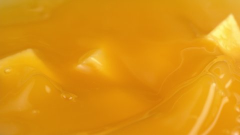 Mango chunks falling into mango juice in slow motion. Shot with Phantom Flex 4K camera.
