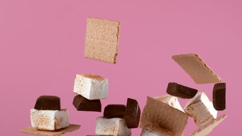 Chocolate, graham crackers and marshmallows on pink background in slow motion. Shot with Phantom Flex 4K camera.