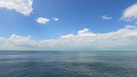 2 colors of navy blue n cyan green sea water surface n calm ocean wave or ripple on beautiful sunny clear sky background with fluffy white cloud or cumulus cloudscape, 4k cinemagraphs b-roll TimeLapse