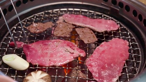 4K UHD Slow motion Handheld : Charcoal grilled Kobe Wagyu beef tenderloin sliced Yakiniku , gourmet Japanese-style bbq.