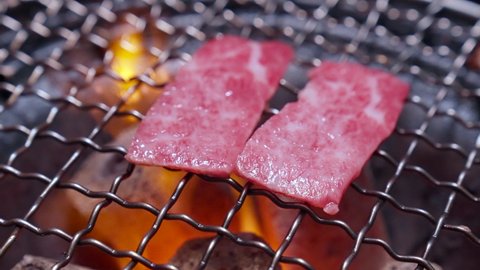 4K UHD Slow motion : Charcoal grilled Kobe Wagyu beef sliced Yakiniku , gourmet Japanese-style bbq.